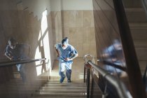Low angle view of surgeon in uniform walking up stairway in modern hospital. — Stock Photo