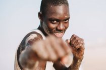 Yoff, Senegal- Dezembro 6, 2017: Retrato de homem africano alegre posando com o punho esticado na câmera . — Fotografia de Stock