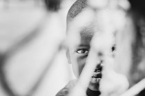 Goree, Senegal- 6 de diciembre de 2017: Retrato oculto del niño mirando a la cámara . - foto de stock
