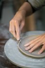 Mãos artesanais cultura esculpir borda prato de argila com instrumentos — Fotografia de Stock