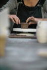 Metà sezione di donna che forma pentola da argilla sul tavolo — Foto stock