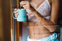 Frau im Mittelteil im BH trinkt Kaffee — Stockfoto