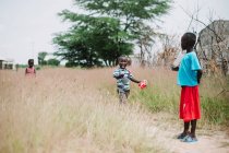 Senegal- 6. Dezember 2017: Kleine Kinder laufen gemeinsam im Gras auf der Wiese. — Stockfoto