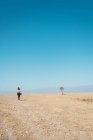 Back view of woman walking on sandy desert landscape — Stock Photo