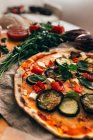 Close up view of fresh baked homemade pizza and ingredients on table — Stock Photo