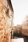Vista de la calle de la ciudad corriendo hacia abajo entre los edificios antiguos en la luz del sol brillante mañana . - foto de stock