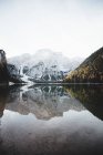 Pittoresco lago di montagna calmo e montagna innevata sullo sfondo — Foto stock