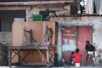 Goree, Senegal - 6 de diciembre de 2017: Grupo de niños sentados cerca del garaje y conversando entre sí . - foto de stock