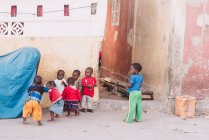 Goree, Senegal - 6 de dezembro de 2017: Grupo de crianças africanas brincando na rua da pequena cidade africana
. — Fotografia de Stock