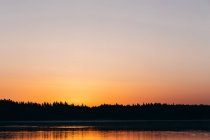 Céu dourado do por do sol acima do lago calmo — Fotografia de Stock