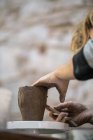 Crop of female potter making pot with clay — Stock Photo