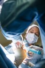 Vista da vicino delle mani dei medici che conducono l'operazione in sala operatoria — Foto stock