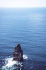 Вид на твердую породу в синем океане — стоковое фото