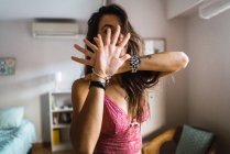 Laughing brunette girl in lingerie covering face with palms — Stock Photo