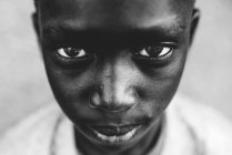 Goree, Senegal- 6 de diciembre de 2017: Retrato de un chico negro serio mirando a la cámara . - foto de stock