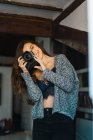 Portrait of cheerful brunette in casual posing with photo camera and taking photo. — Stock Photo