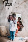 Goree, Sénégal- 6 décembre 2017 : Des enfants joyeux jouent ensemble par trou dans le mur . — Photo de stock