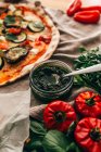 Nahaufnahme von Glas mit grüner Bio-Sauce serviert für köstliche Gemüse-Pizza. — Stockfoto