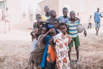 Goree, senegal- 6. Dezember 2017: Gruppe afrikanischer Kinder posiert gemeinsam gestikulierend mit V-Zeichen vor der Kamera auf der armen Straße. — Stockfoto