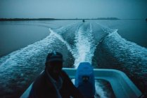 Ritratto di uomo seduto in barca a motore e che lo guida al crepuscolo della sera, Yoff, Senegal — Foto stock