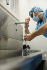 Вид сбоку на мытье рук хирургом перед операцией — стоковое фото