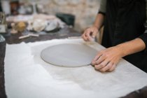 Coltivazione femminile artigianale con cerchio di argilla su tavola in studio di ceramica — Foto stock
