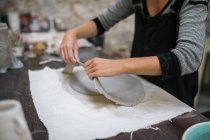 Середина жіночого гончаря, що відділяє порізи від глини — стокове фото