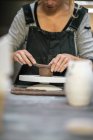Mid section of woman in apron working with clay — Stock Photo