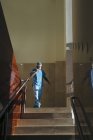 Cirurgião falando ao telefone e andando na passagem de escada no corredor do hospital — Fotografia de Stock