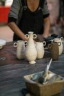Pots artisanaux en argile sur table en bois à l'atelier de poterie — Photo de stock