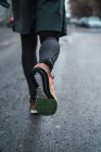 Низька частина бігуна в теплому спортивному одязі, що йде по вулиці . — стокове фото