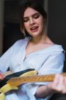 Porträt einer fröhlichen Frau, die Gitarre spielt — Stockfoto