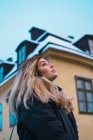 Hochwinkel-Seitenansicht der blonden Frau, die auf der Winterstraße wegschaut — Stockfoto
