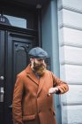 Портрет вдумчивого бородатого человека, смотрящего на часы у входной двери — стоковое фото