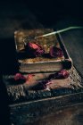 Vista ravvicinata della rosa essiccata sul vecchio libro al tavolo di legno rurale — Foto stock