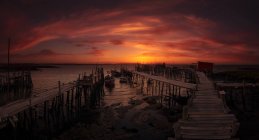Vista verso il mare e i moli di legno nelle luci del tramonto serale . — Foto stock