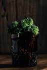 Закрыть вид на свежий пучок брокколи бими в красной банке на деревянном столе . — стоковое фото
