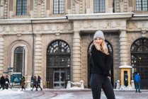 Vorderansicht einer jungen blonden Frau, die in der Winterstadt posiert — Stockfoto