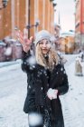 Portrait of blonde woman throwing up snow at winter street — Stock Photo