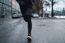 Crop male running on winter street — Stock Photo