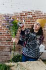 Retrato de mulher em suéter compondo buquê no atelier floral — Fotografia de Stock