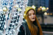 Portrait of woman wearing knitted hat posing at illumination — Stock Photo