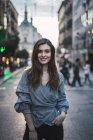 Портрет молодої усміхненої жінки, що позує на міській вулиці — стокове фото