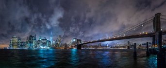 Cityscape view to big bridge and illuminated city towers at night. — Stock Photo