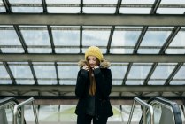 Портрет молодой женщины, позирующей в пальто в торговом центре — стоковое фото