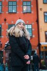 Porträt einer blonden jungen Frau, die im Winter auf der Straße posiert. — Stockfoto