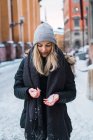 Портрет блондинка дівчина, дивлячись на снігу в руки на вулиці зимова сцена — стокове фото