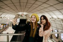Дві усміхнені жінки беруть селфі зі смартфоном — стокове фото