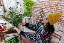 Low angle view of woman arranging flowers at floral atelier — Stock Photo