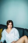 Donna attraente posa sul divano a guardare la fotocamera — Foto stock